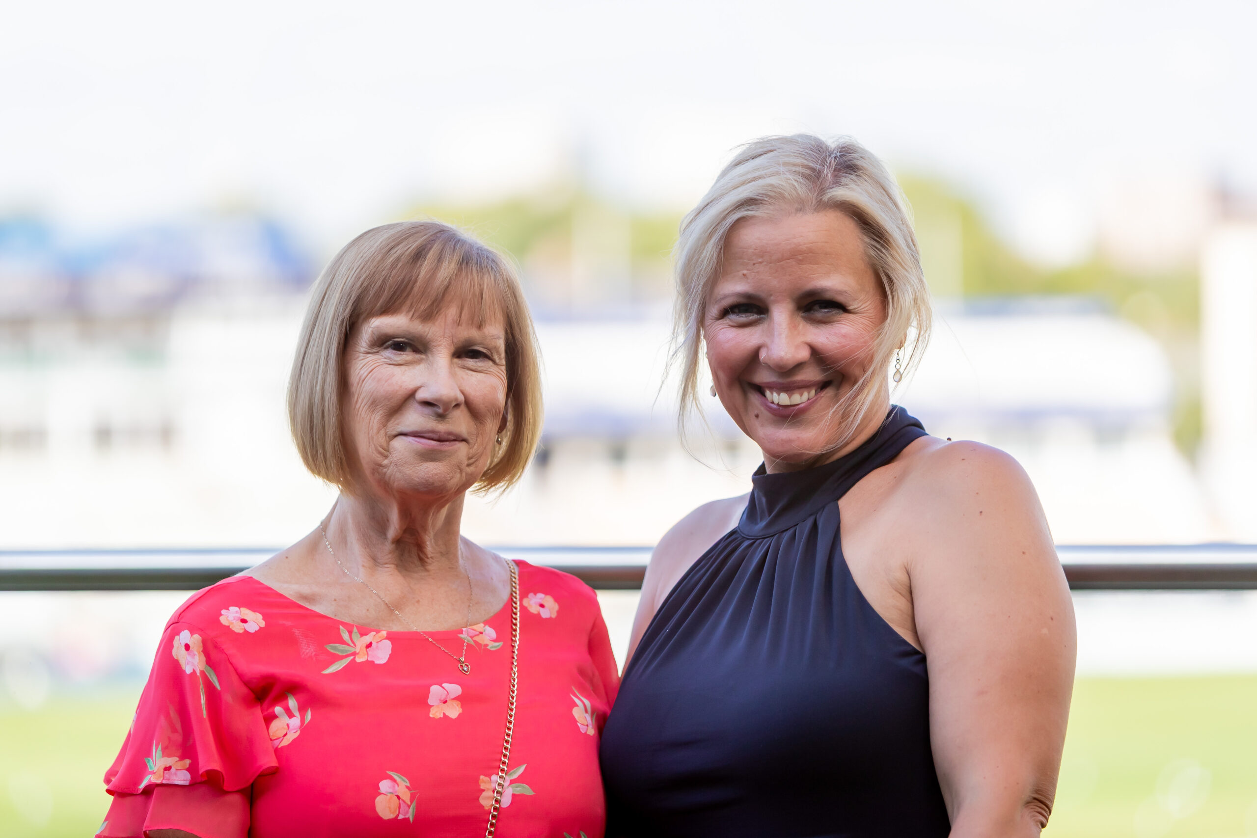 Two women, one older and one younger, smiling and posing together.