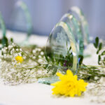 Glass awards on a table with floral decorations for an educational event