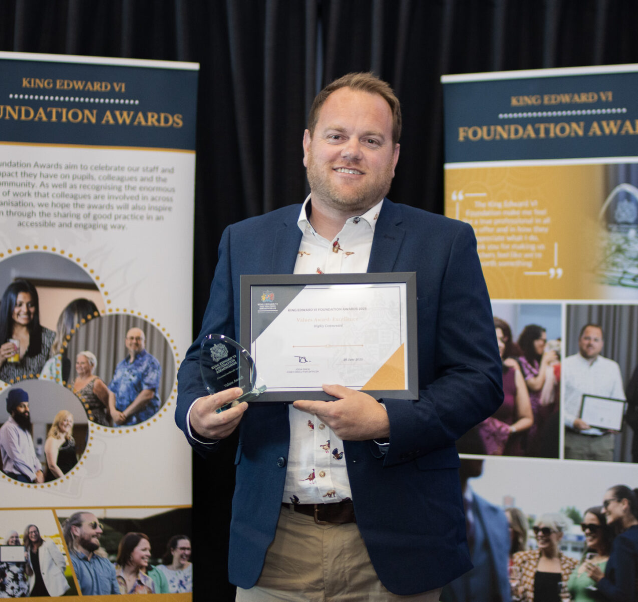 A man proudly holding an award and certificate at the Kevi Foundation Awards, celebrating academic achievement.
