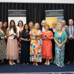 Group of students and faculty at Kevi Foundation event, posing for a photo with awards