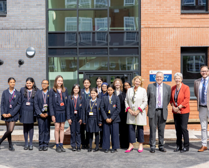 Group of students and adults standing together outside a modern building, promoting campus safety and educational activities.